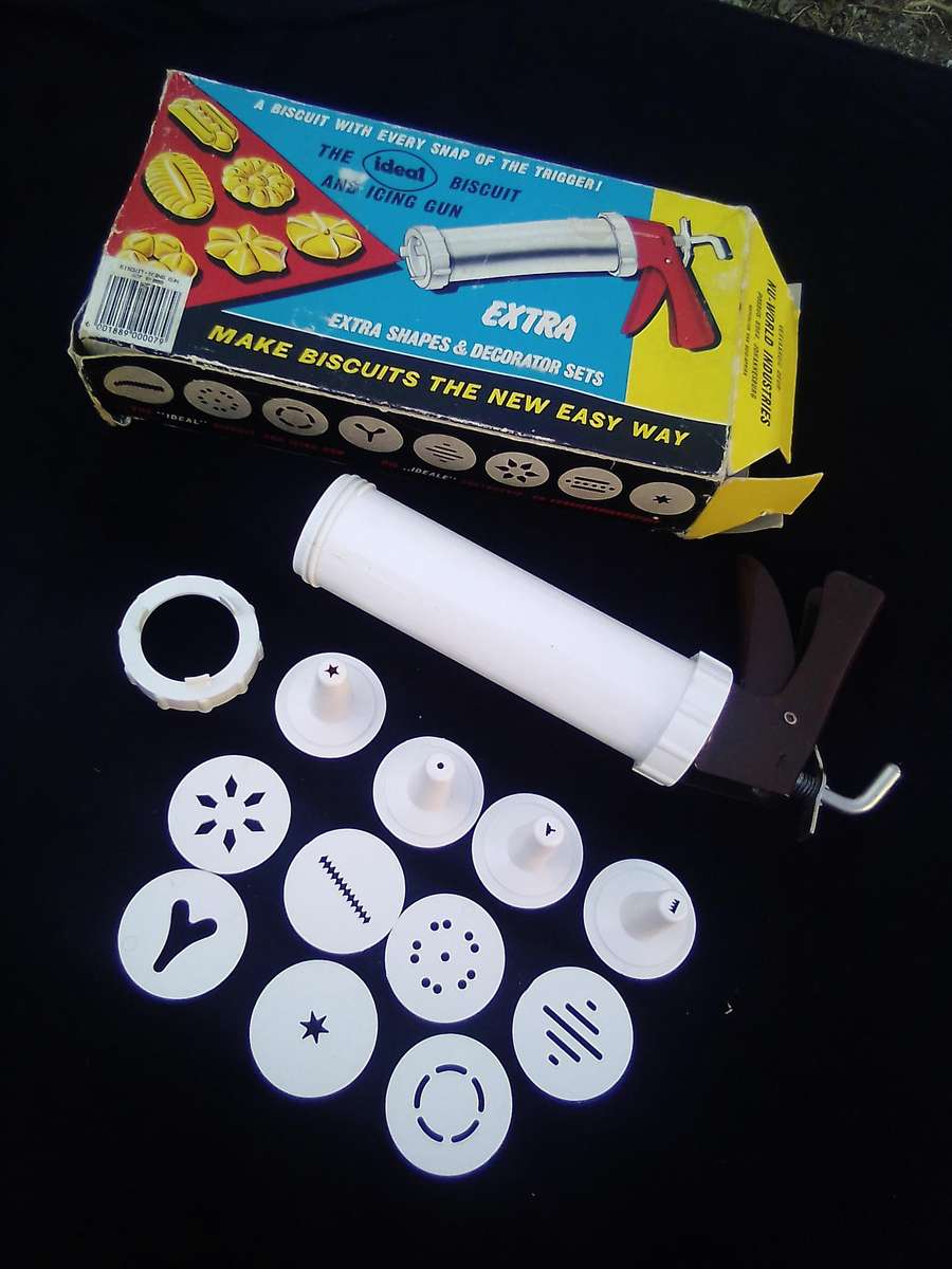 "Ideal" Biscuit and Icing Gun.  Metal trigger, tube and attachments are hard, white plastic.