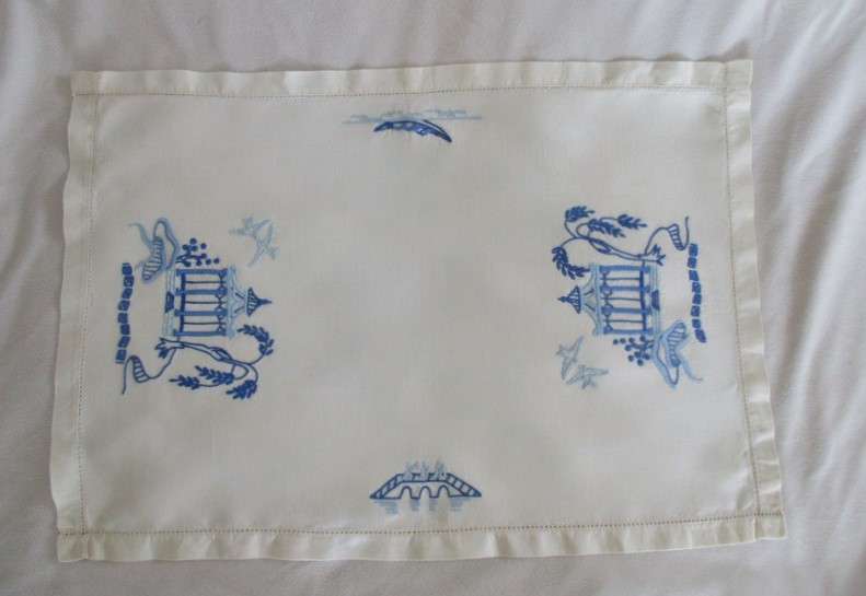 A blue and white hand embroidered tray cloth with oriental design