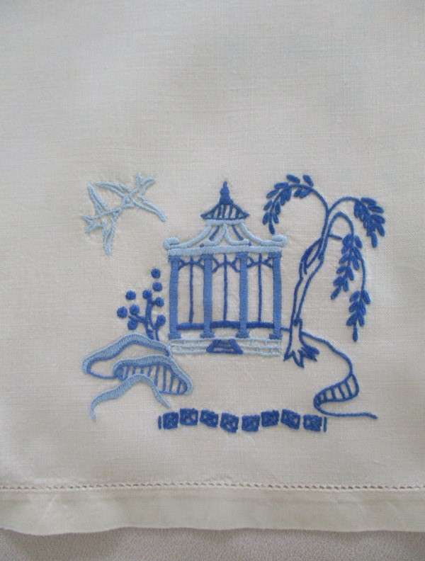 A blue and white hand embroidered tray cloth with oriental design