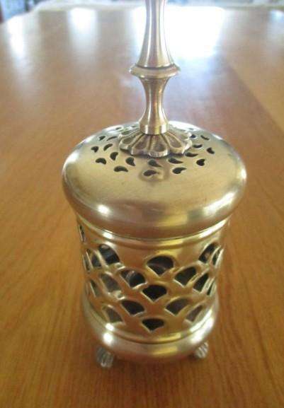 A lovely ornate footed brass lantern-style candle holder