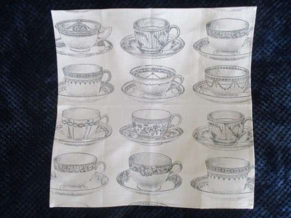 A square, quality cloth with pretty teacups