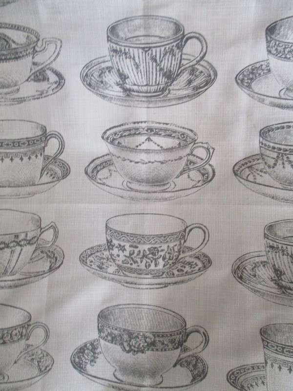 A square, quality cloth with pretty teacups