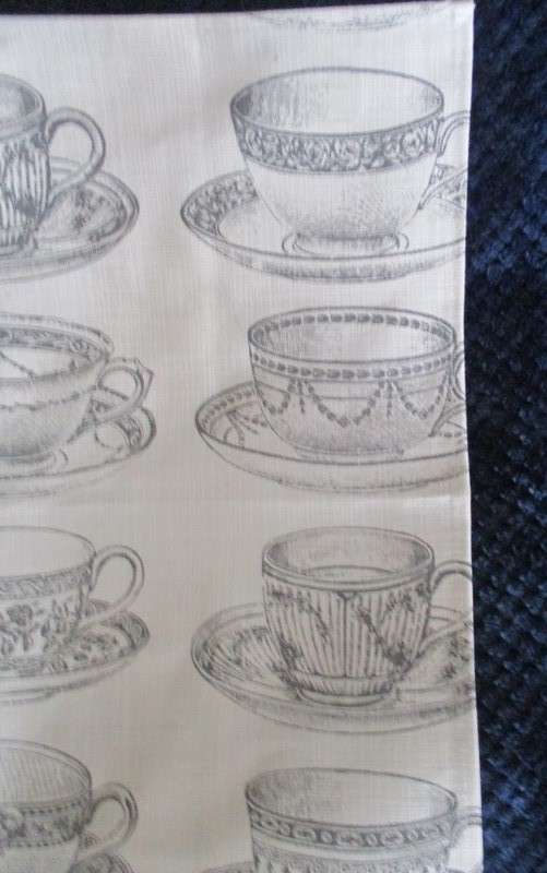A square, quality cloth with pretty teacups