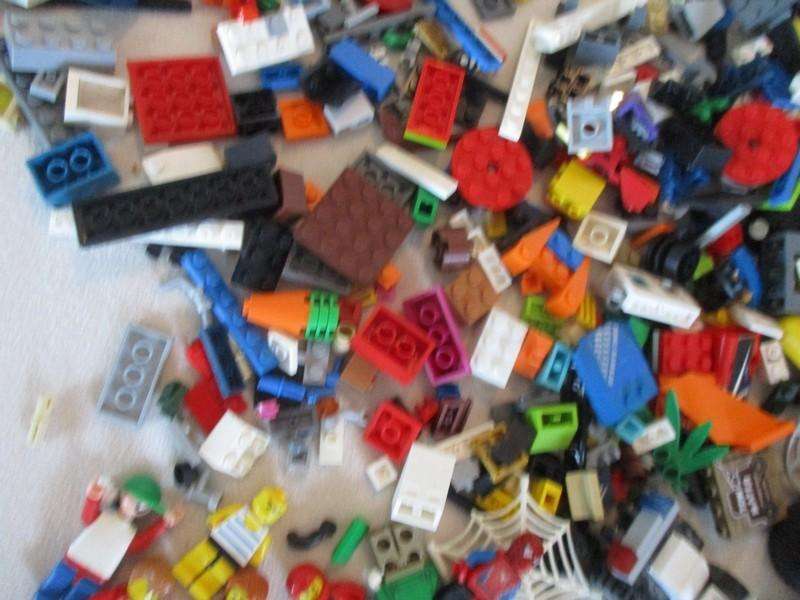 A batch of over 2500 real Lego pieces - lots of figures and wheels