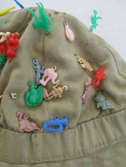 Vintage plastic charms - 62 of them on an old khaki hat!