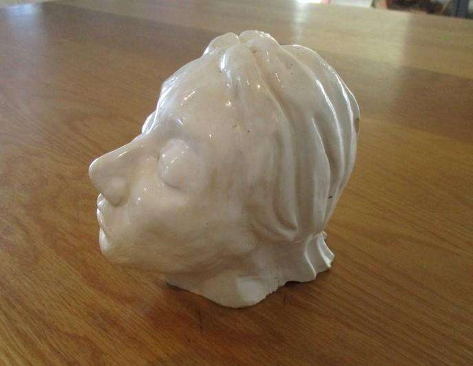 A vintage shabby chic glazed pottery head for inside or outside