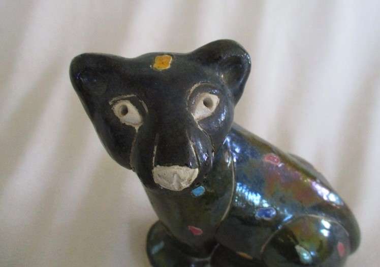 A unique, Unusual Raku leopard glazed in iridescent colours - initialled by artist