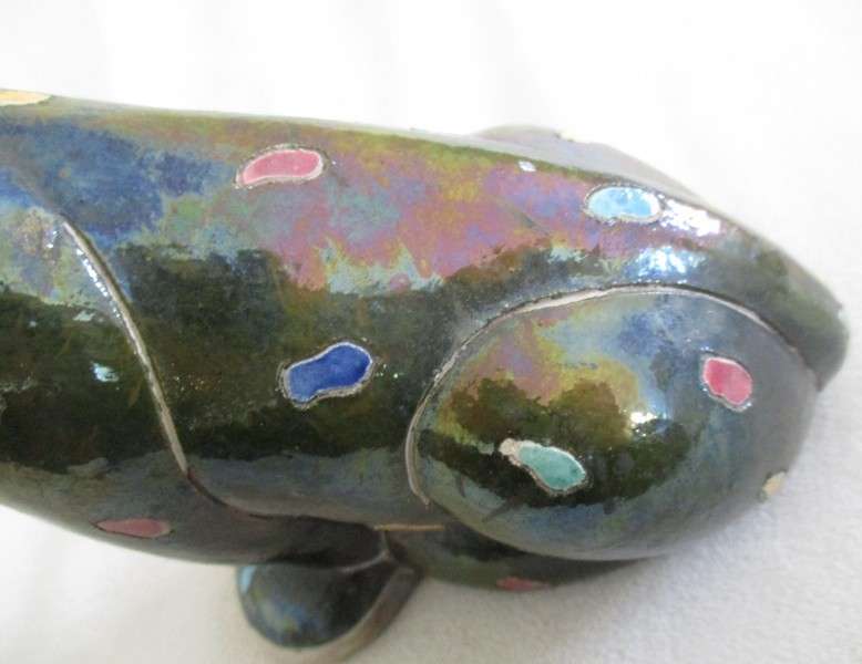 A unique, Unusual Raku leopard glazed in iridescent colours - initialled by artist