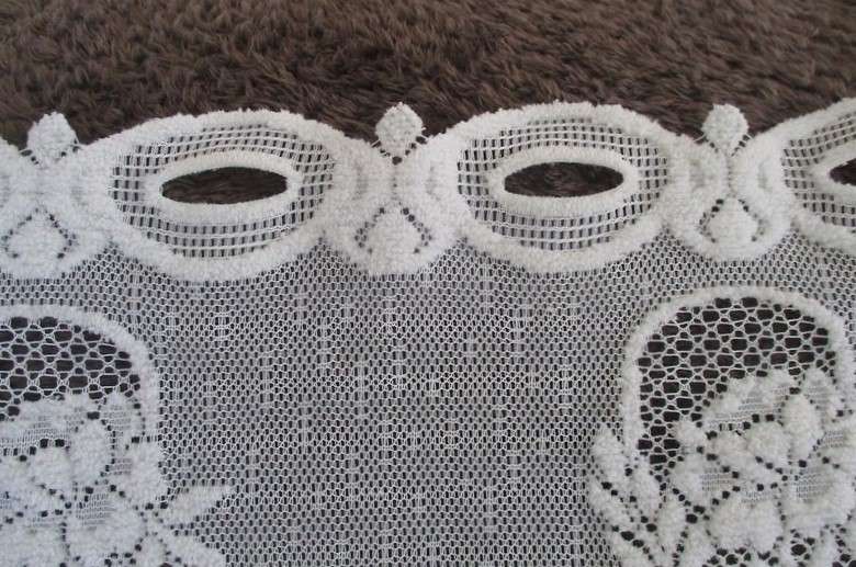 A special vintage `half mast` lace curtain with textured flowers in basket design