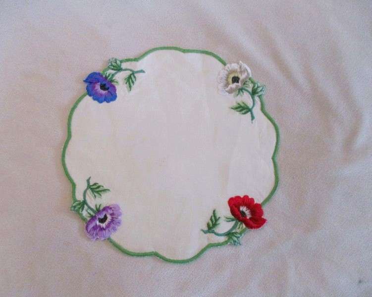Two beautifully embroidered doilies with colourful anemones
