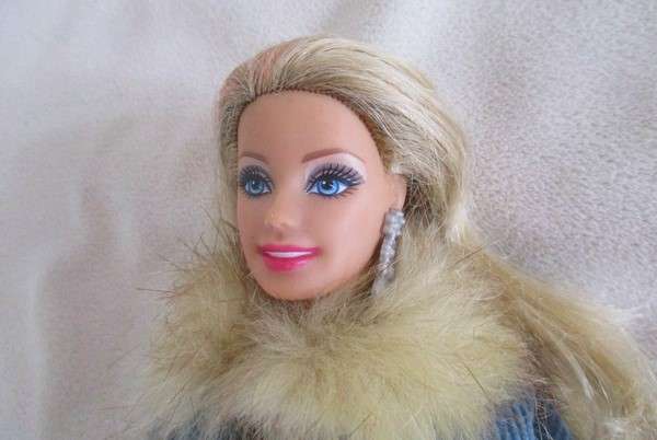 A very pretty Mattel Barbie with original earrings and knees that bend - lovely "fur" lined coat