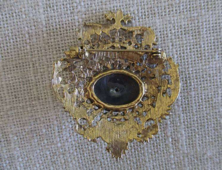 Pretty vintage gold tone brooch intricate filigree border