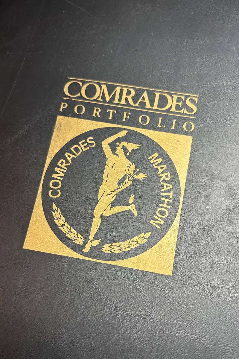 Comrades Marathon Folder with 11 medals, cloth badges etc.