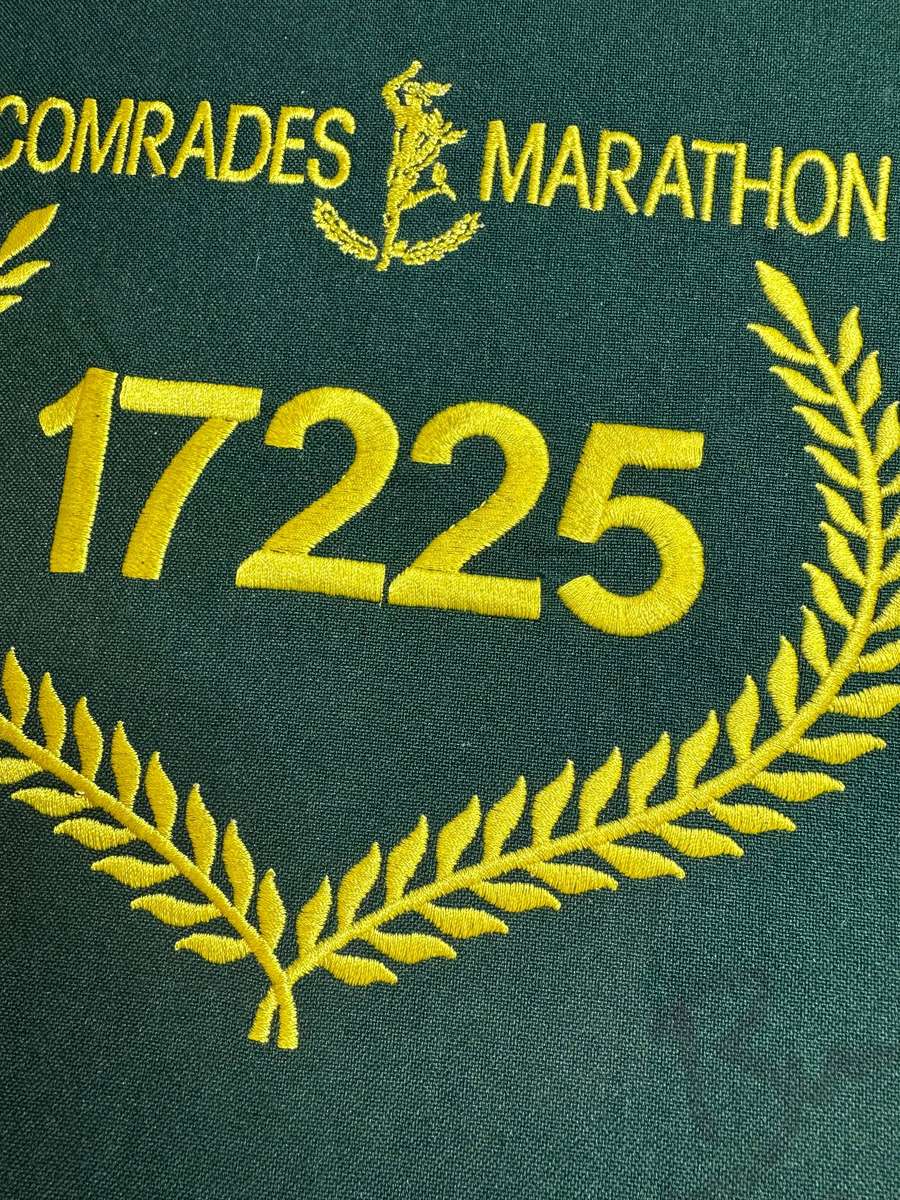 Comrades Marathon Folder with 11 medals, cloth badges etc.