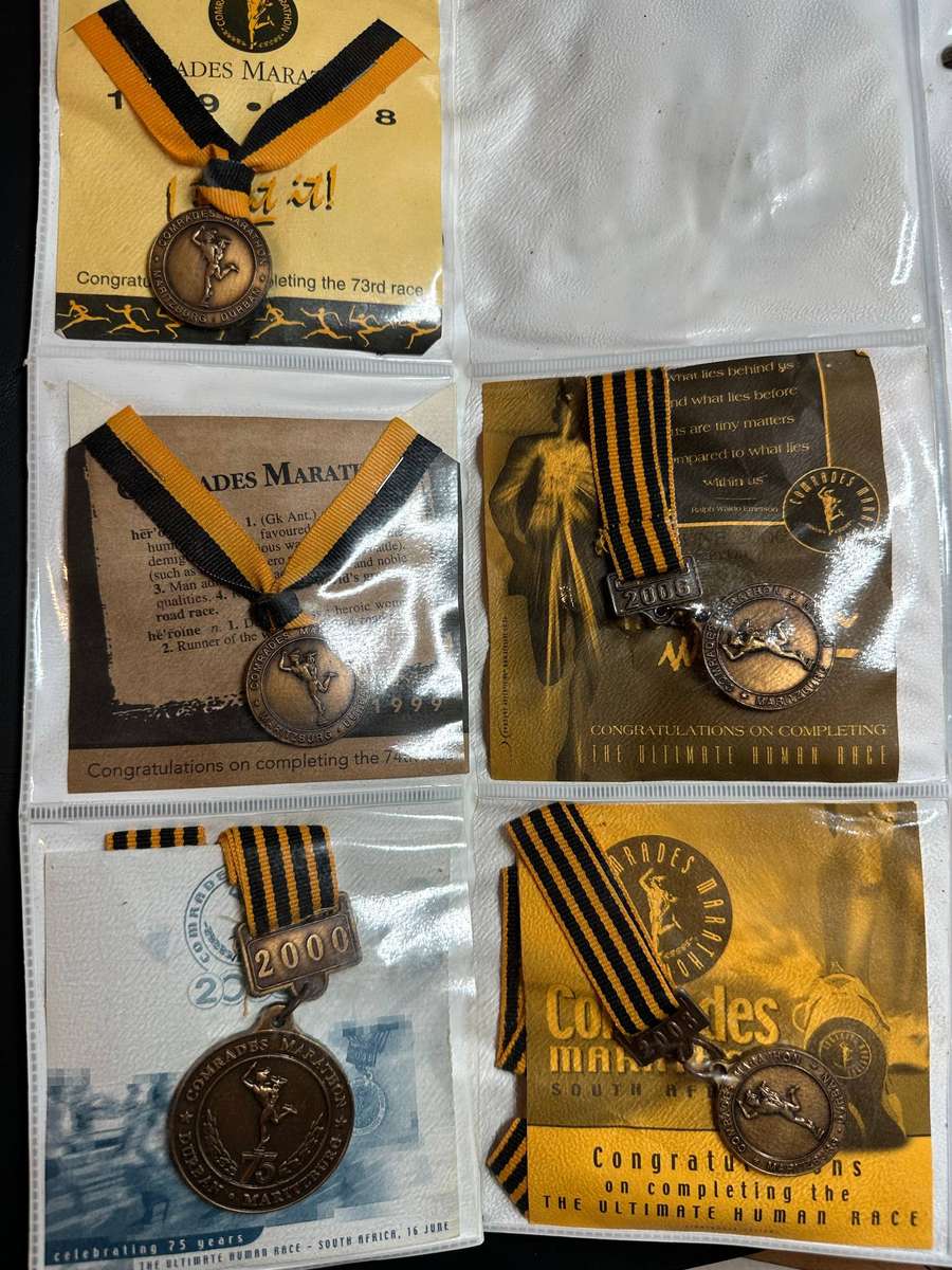 Comrades Marathon Folder with 11 medals, cloth badges etc.