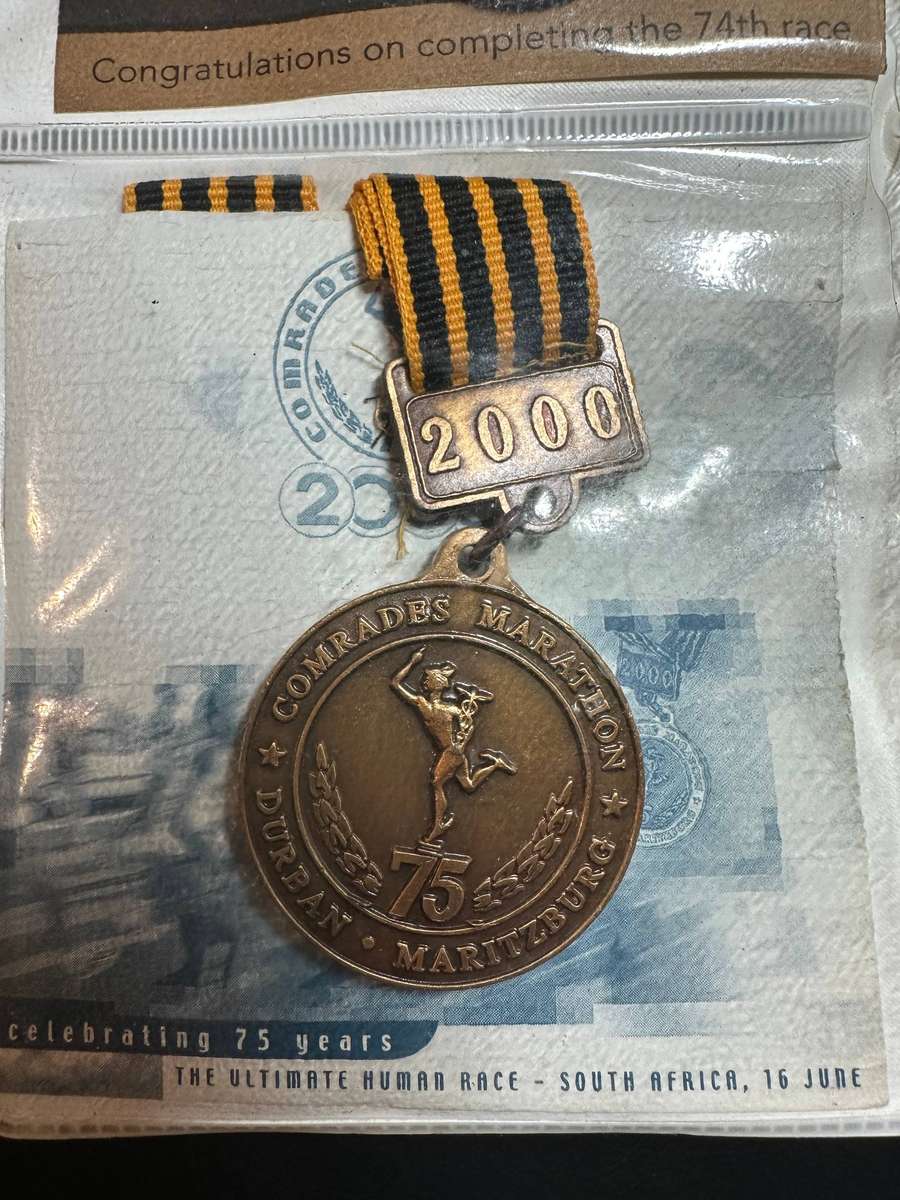 Comrades Marathon Folder with 11 medals, cloth badges etc.