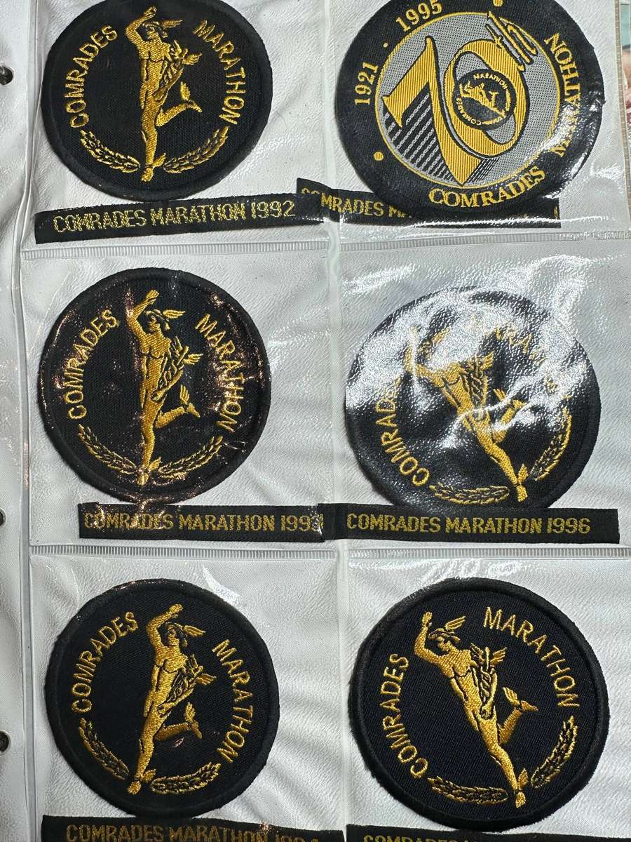 Comrades Marathon Folder with 11 medals, cloth badges etc.