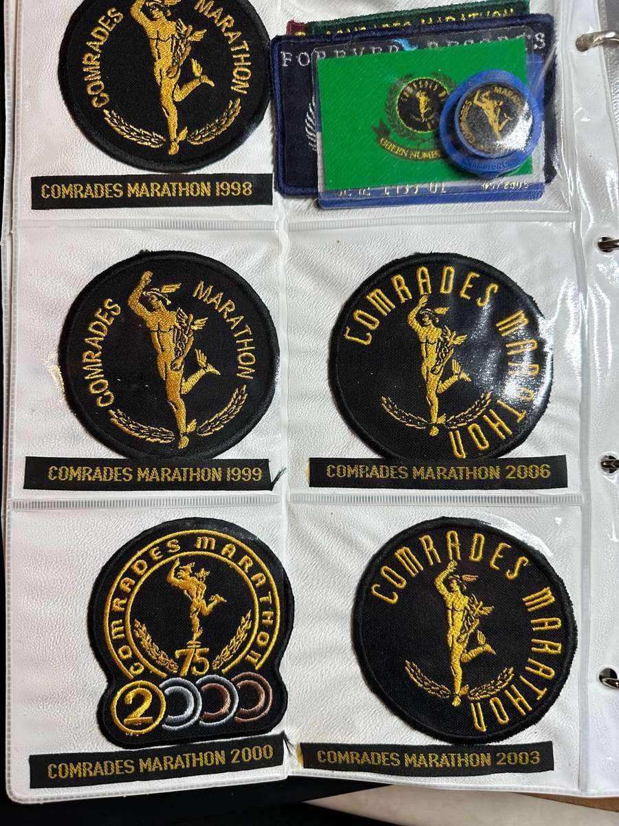Comrades Marathon Folder with 11 medals, cloth badges etc.