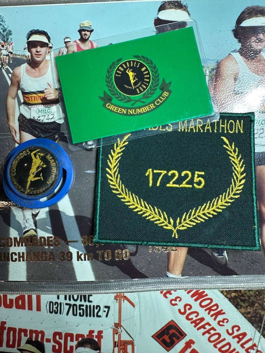 Comrades Marathon Folder with 11 medals, cloth badges etc.