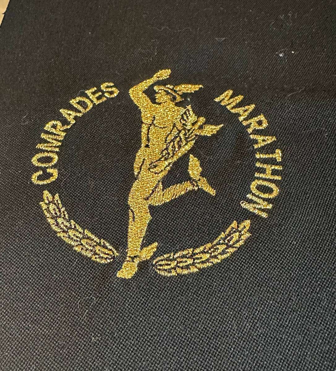Comrades Marathon Folder with 11 medals, cloth badges etc.