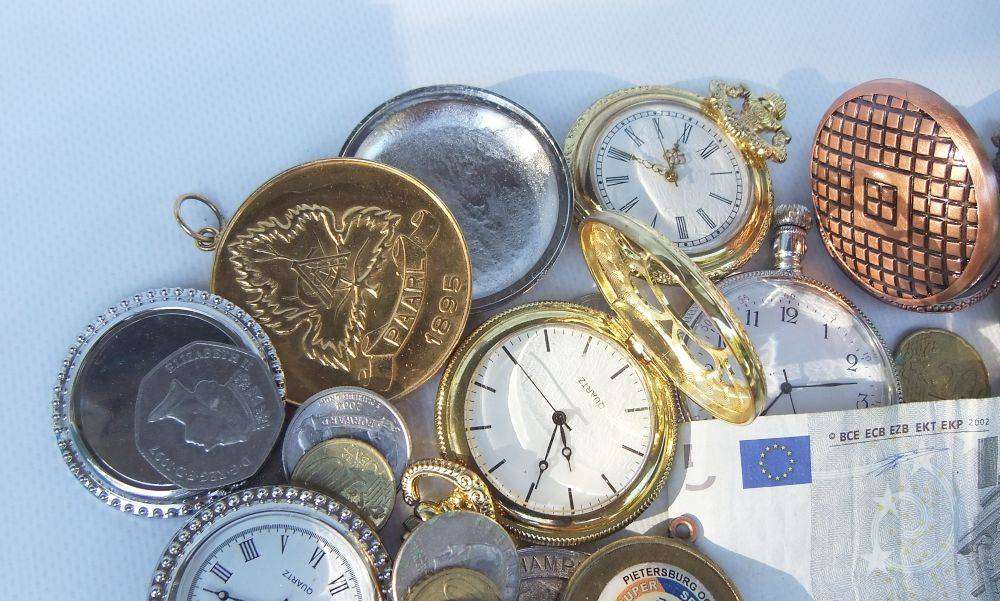 A bunch of medallions , over 100 world coins + 5 Euro note and allot of spare watch parts