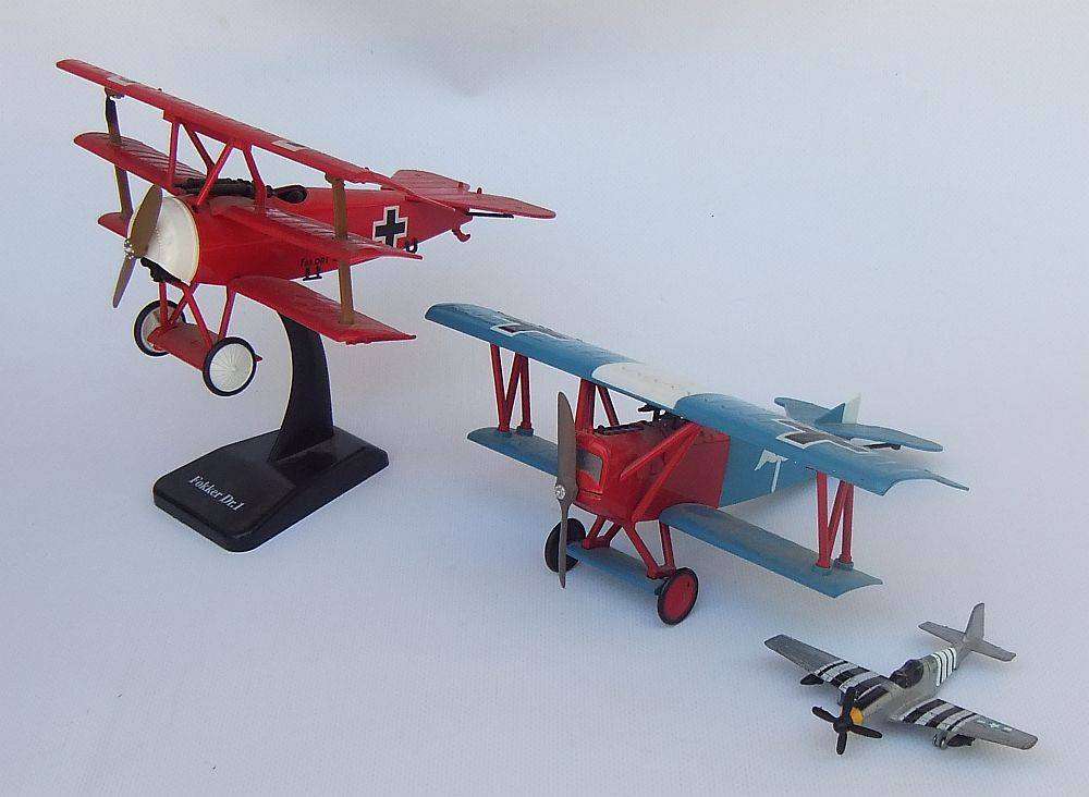 Three airplane models , two hardened plastic models by New Ray and a die cast metal model