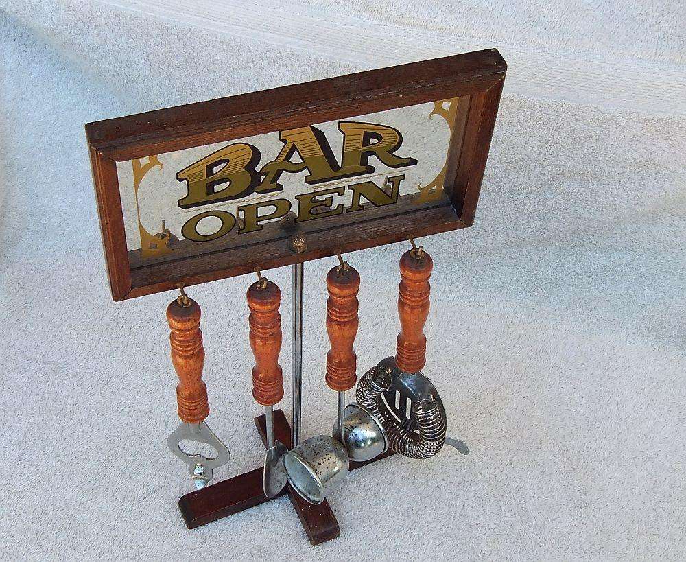 A vintage bar tool stand with mirror and accessories