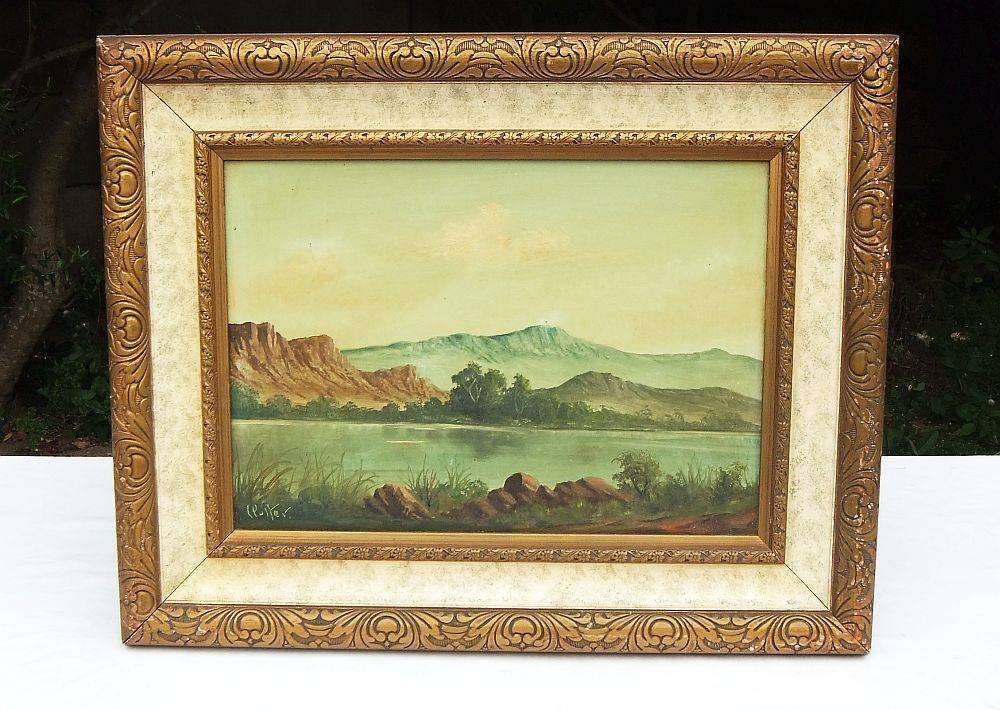 An original framed vintage oil painting depicting a lake scene signed by the artist