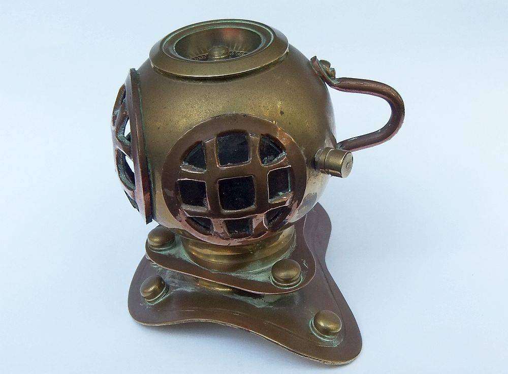A vintage brass and copper miniature divers helmet ornament with hidden sharpener plus compass