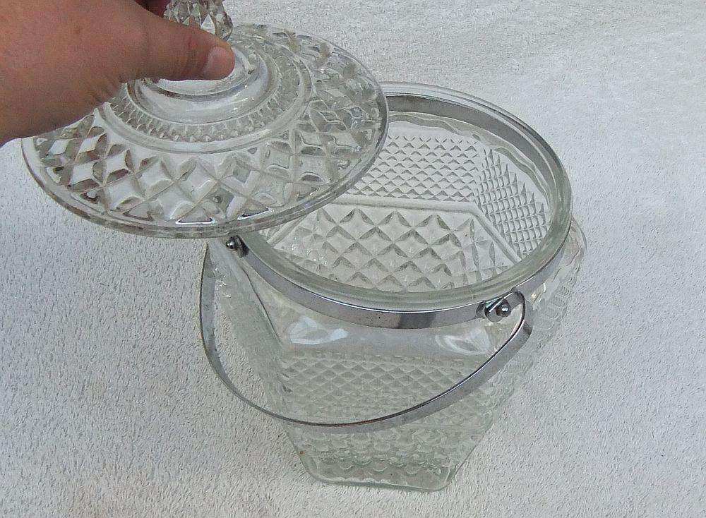 A large vintage molded glass cookie jar with metal handle