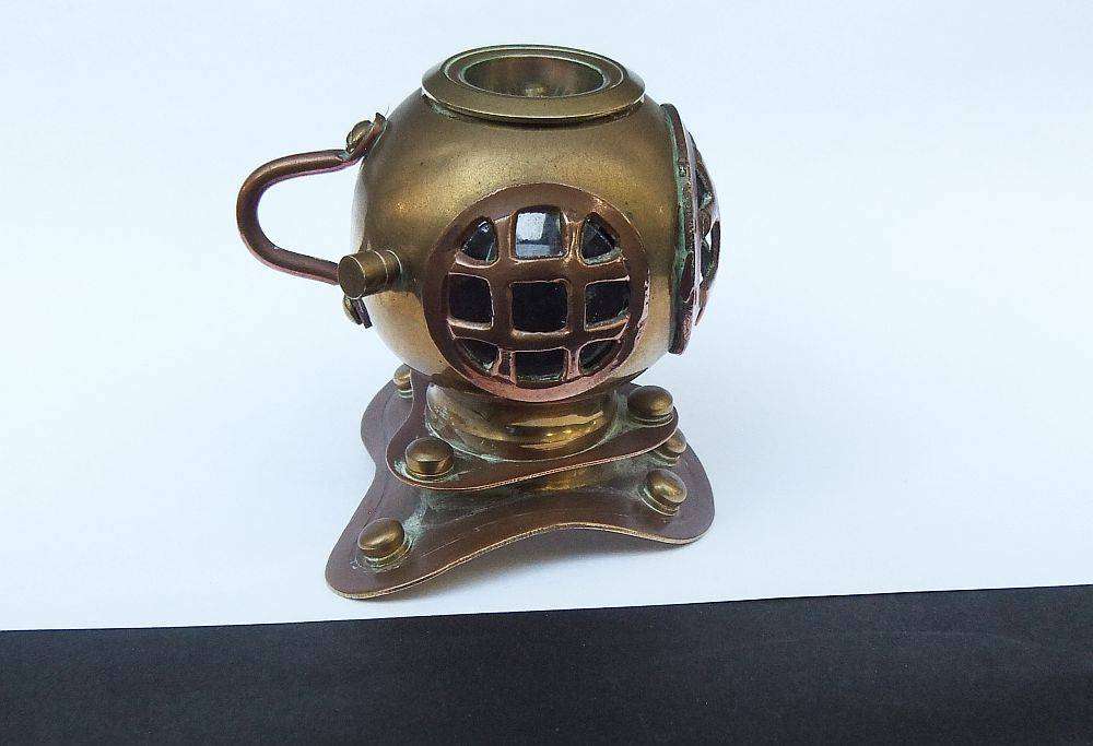 A vintage brass and copper miniature divers helmet ornament with hidden sharpener plus compass