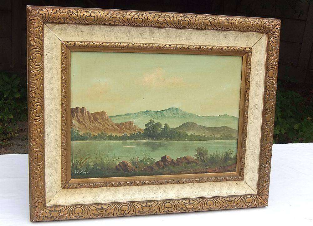 An original framed vintage oil painting depicting a lake scene signed by the artist