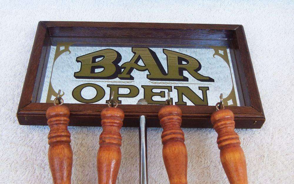 A vintage bar tool stand with mirror and accessories