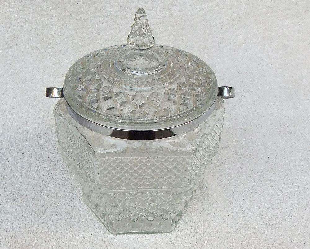 A large vintage molded glass cookie jar with metal handle
