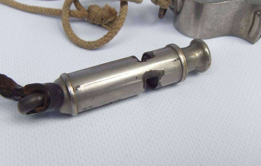 An antique 1917 WW1 whistle and a vintage The Acme Thunderer whistle
