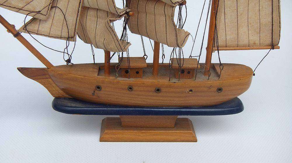 A detailed vintage wooden model of a sail ship with cloth sails