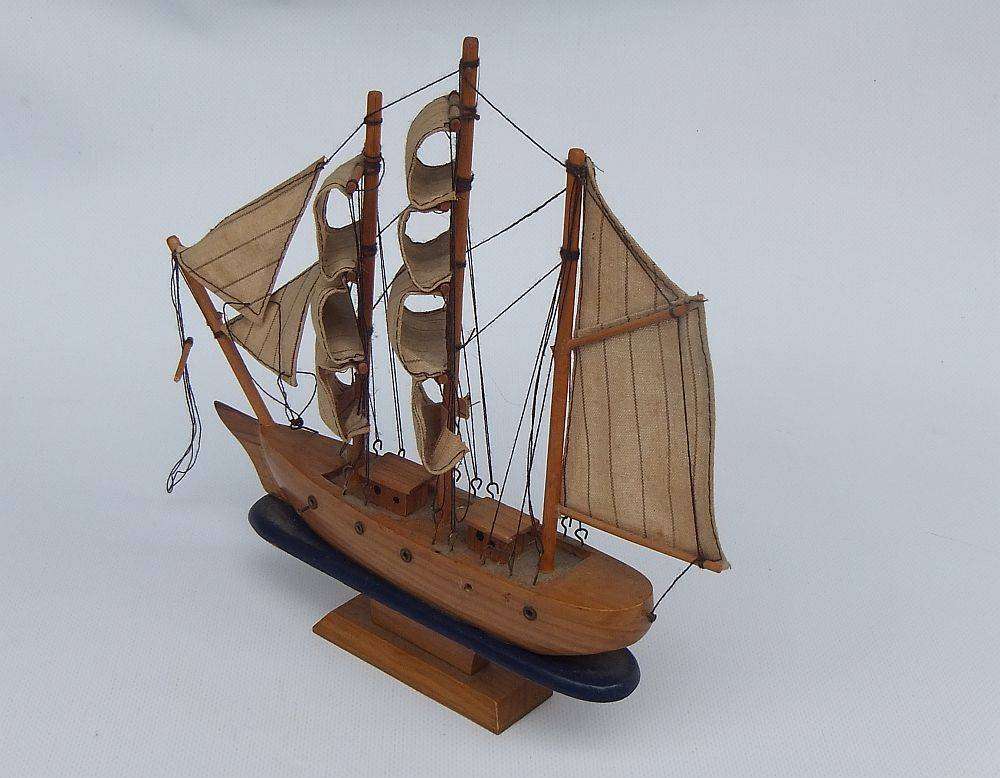 A detailed vintage wooden model of a sail ship with cloth sails