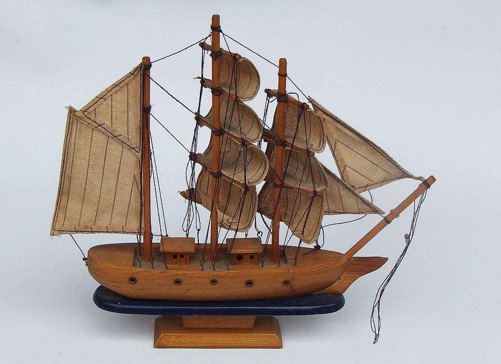 A detailed vintage wooden model of a sail ship with cloth sails