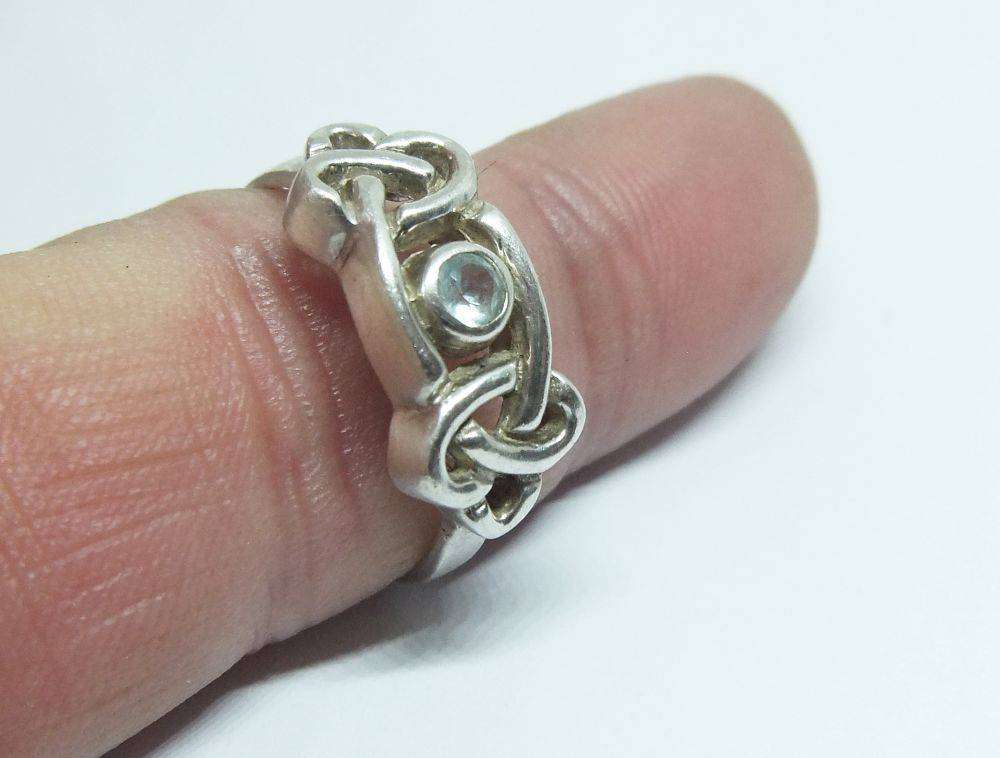 A stunning Celtic motif sterling silver ring set with a faceted pale blue stone