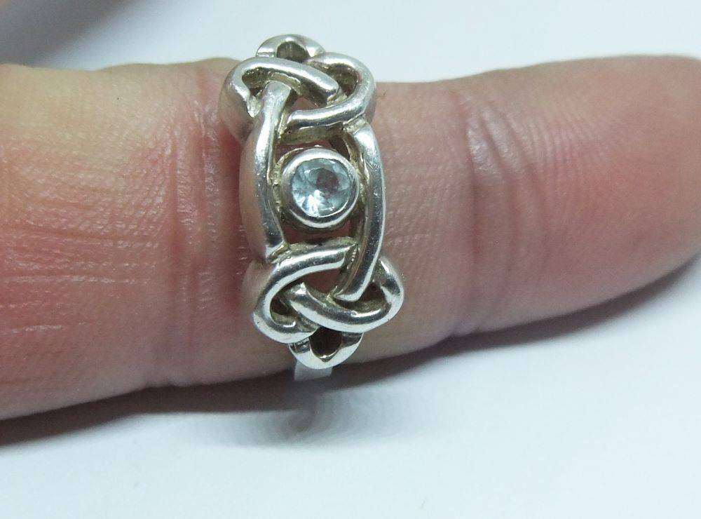 A stunning Celtic motif sterling silver ring set with a faceted pale blue stone