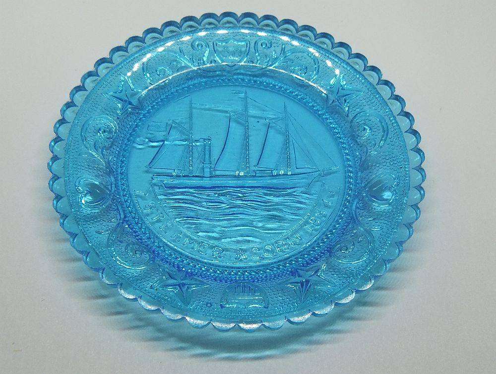 A boxed miniature blue pressed glass plate commemorating the Acorn Steamship in excellent condition