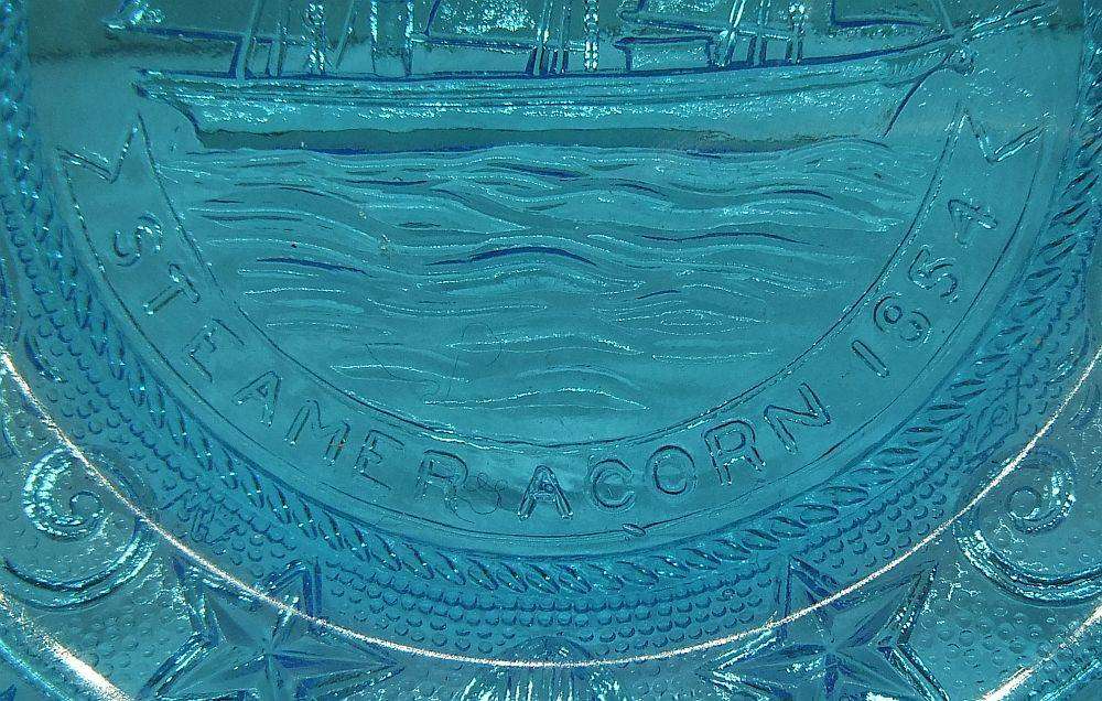 A boxed miniature blue pressed glass plate commemorating the Acorn Steamship in excellent condition