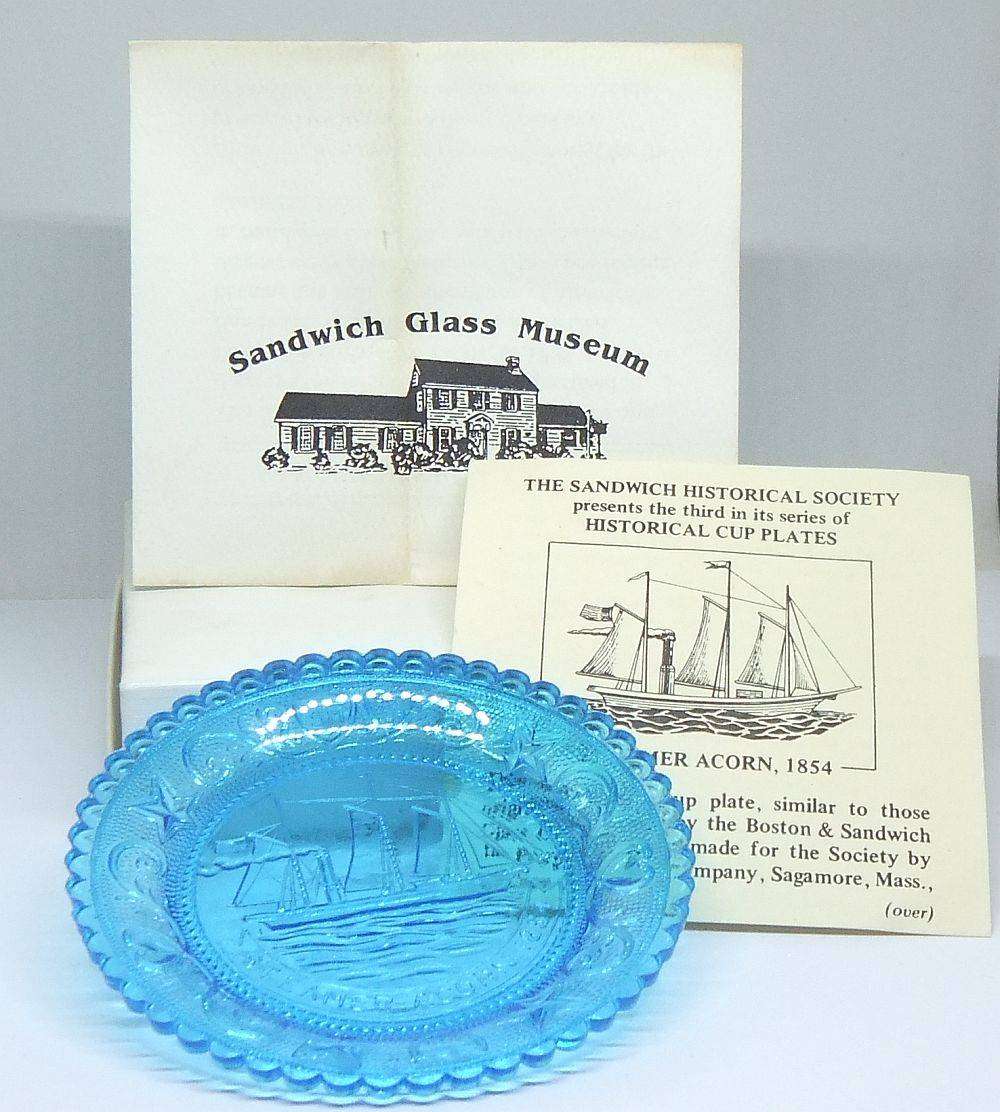 A boxed miniature blue pressed glass plate commemorating the Acorn Steamship in excellent condition