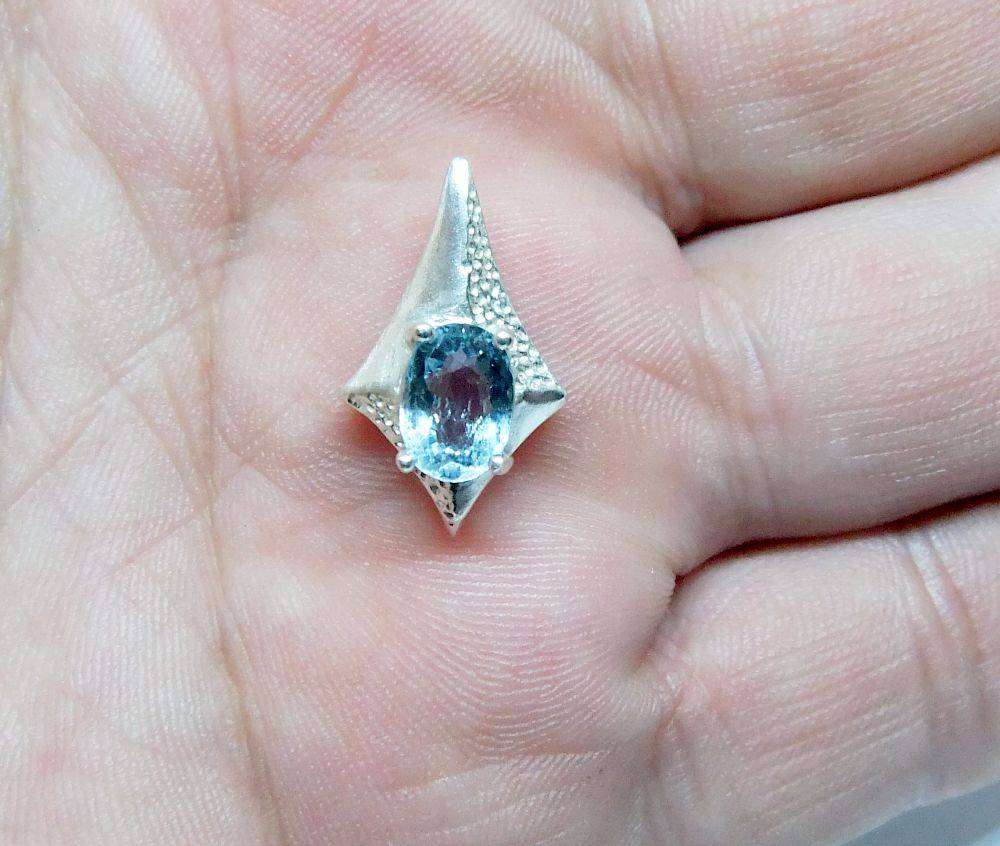 A unique vintage sterling silver pendant with a gorgeous faceted blue inset
