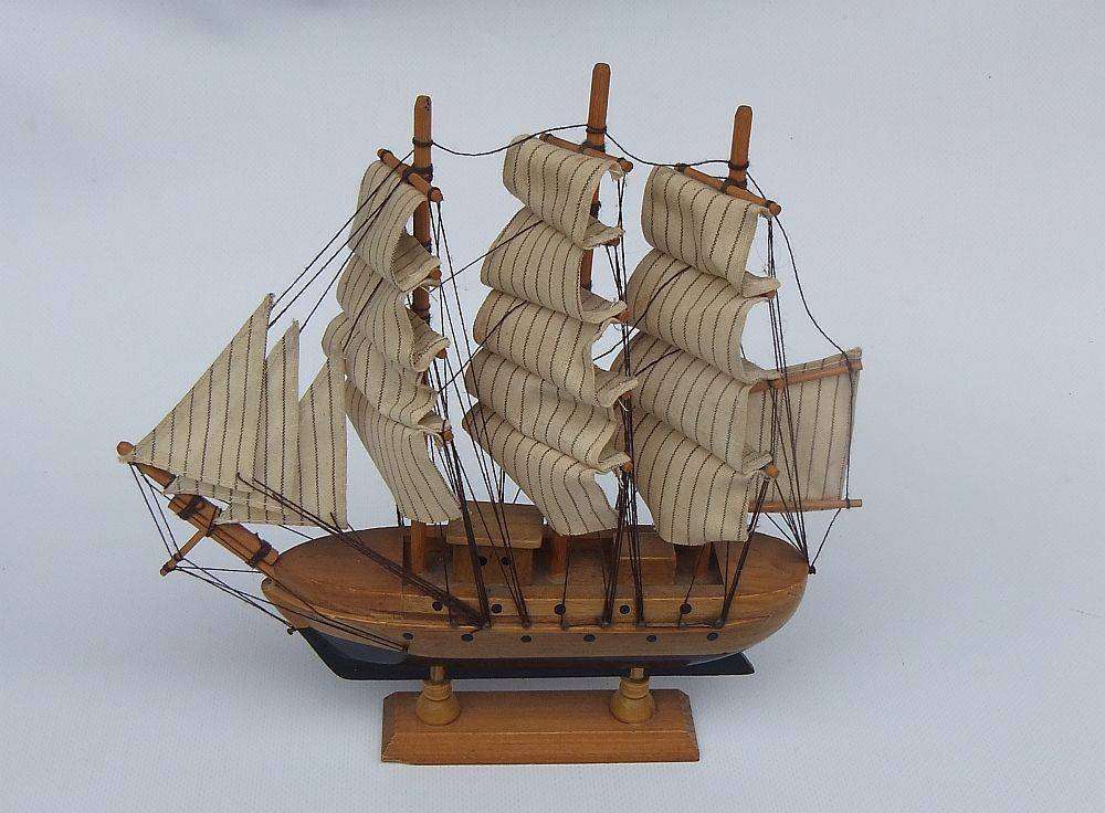 A detailed vintage model of a sailing ship with cloth sails