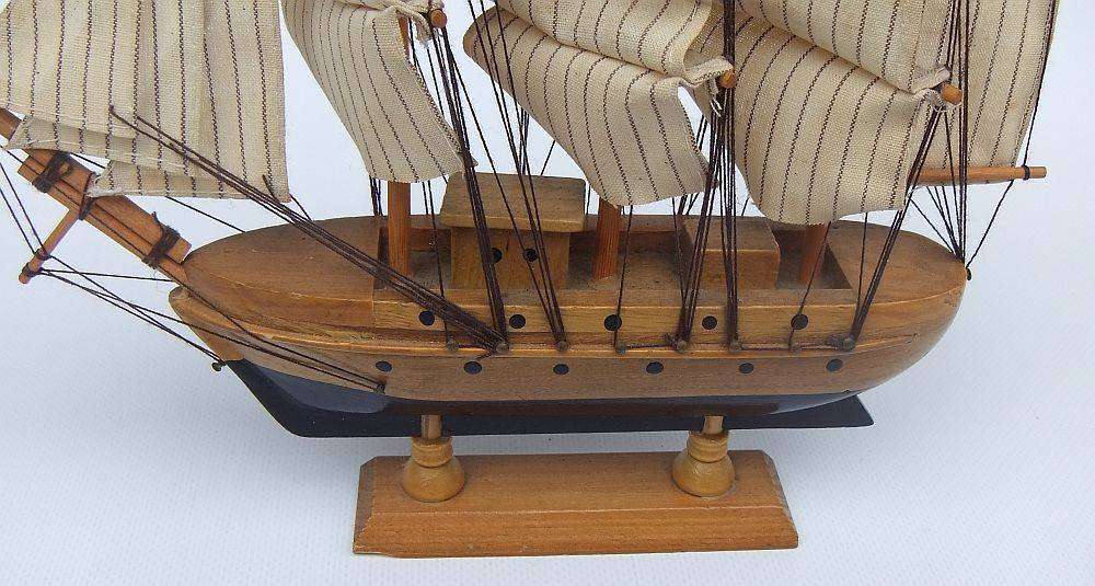 A detailed vintage model of a sailing ship with cloth sails