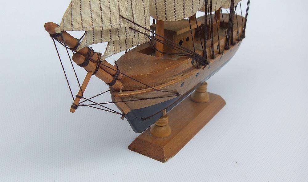 A detailed vintage model of a sailing ship with cloth sails