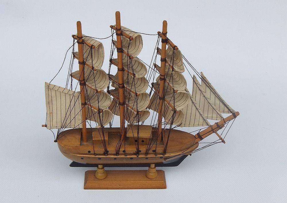A detailed vintage model of a sailing ship with cloth sails