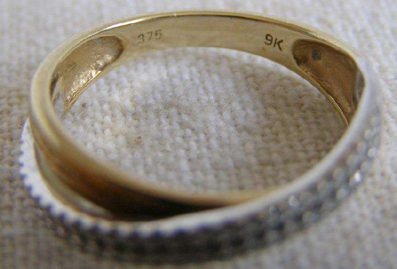 Gorgeous 9ct Gold cross over ring. 50 brilliant cut diamonds. Size O. 2.4g Valuation certificate.