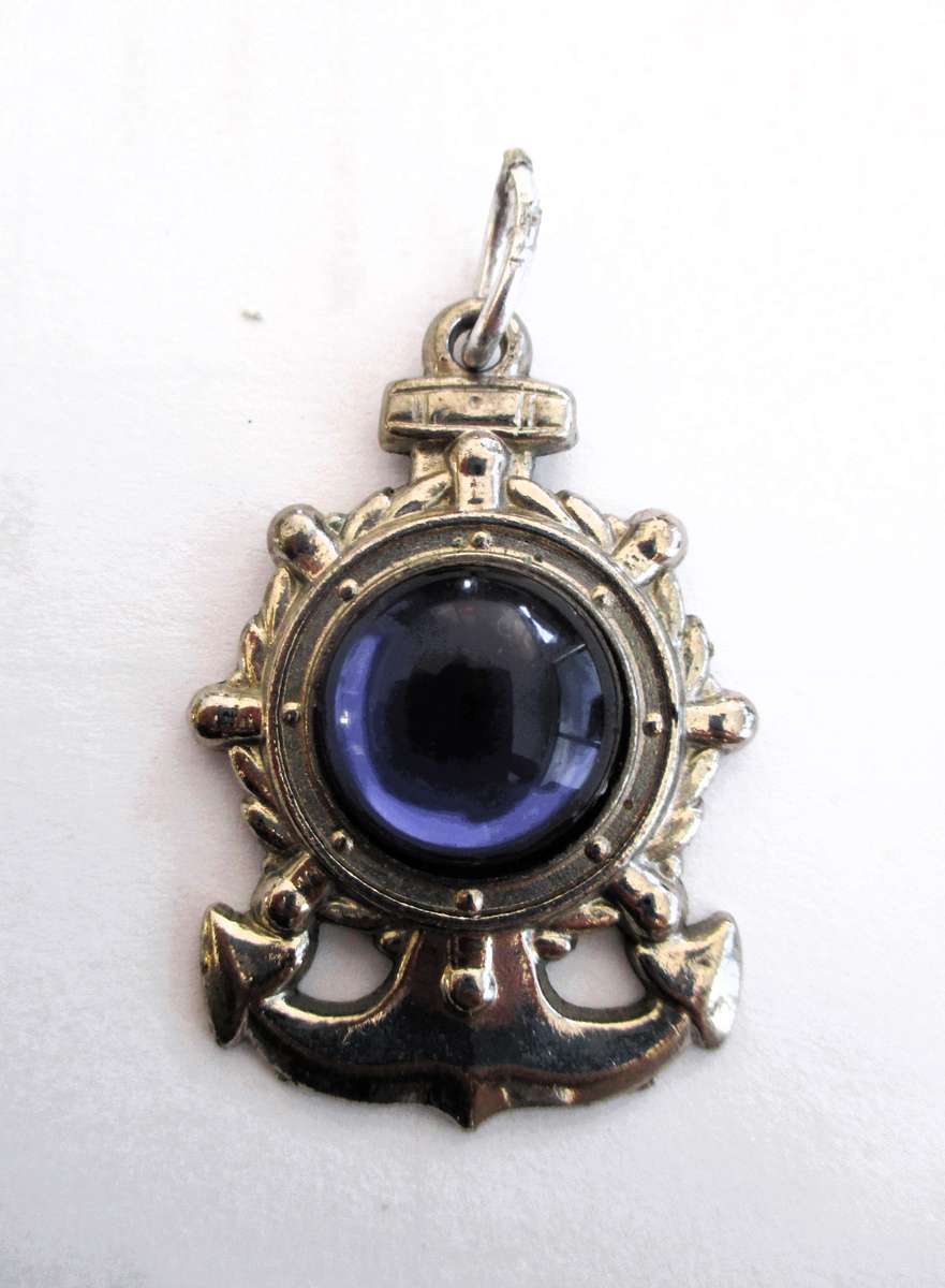 Vintage Ships Wheel Siler olor pndant with Blue centre. Lovely item. 40mm long.